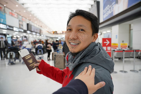 候机时手抚亚洲肩在机场迎接朋友手拿大行李护照旅客和友好的概念现代经过肖像图片