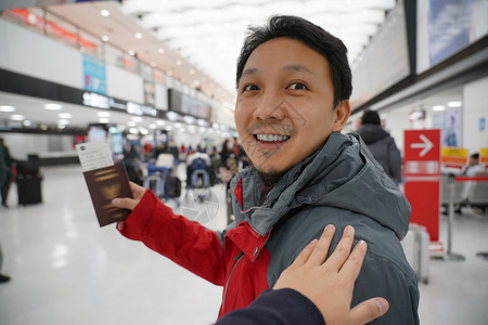 快乐的候机时手抚亚洲肩在机场迎接朋友手拿大行李护照旅客和友好的概念有趣亚洲人图片