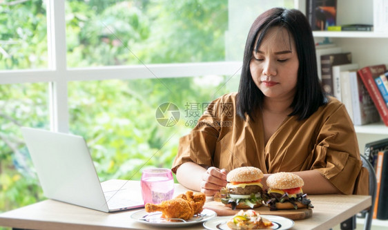 手可口超重餐桌上的炸鸡和披萨在家工作期间体重增问题百食不振BED概念BED家庭饮食紊乱症的概念图片