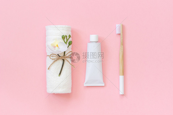 天然环保竹刷白毛巾和牙膏管套装用于在粉红色背景上洗牙和刷在粉红色背景模板设计顶视图平躺个人的齿有机图片