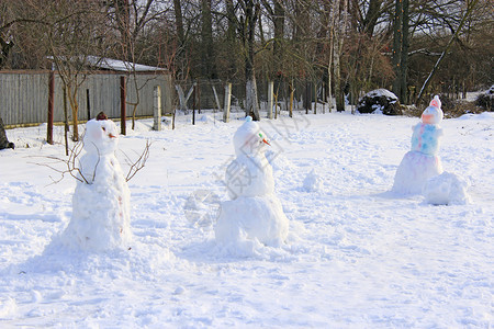 孩子们搭建的雪人花园里圣诞雪人新年属圣诞符号冬天的几个雪人花园里的圣诞雪人村庄建成寒冷的图片