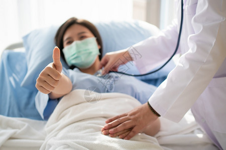 躺在床上戴口罩的女病人竖起拇指图片