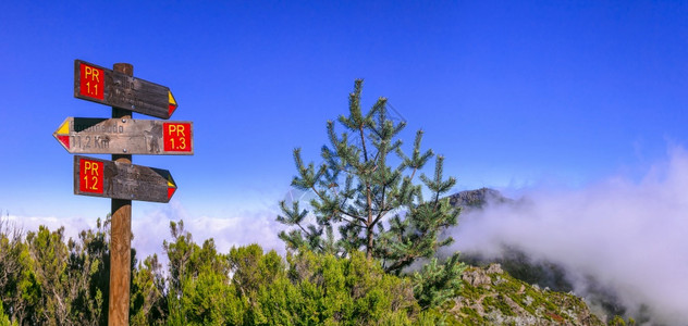 马德拉岛岩石山脉的登活动皮科鲁伊沃最高点的指路标志飞过云层步行瑞沃惊人的图片