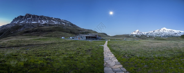 锻炼绿色高山草原通往上一座小屋的道路天空中满月夜景观光图片