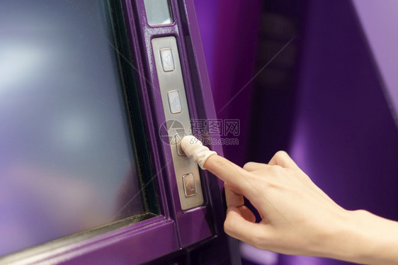 金融的妇女佩戴橡皮手指按自动取款机按钮银行业服务图片