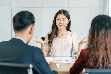 年轻亚洲女毕业生与两名经理面谈在会议室企业雇用新会员工作面试经理概念等积极动议下对两名经理进行访谈商业聘用新成员合同信心人们图片