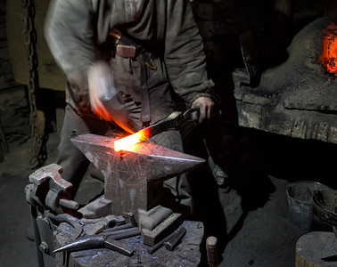 带有smithrsquos锤子的blacksmithrsquos手是热金属加的体力劳动概念和新产品创造手是热金属加的真正技能铁匠图片