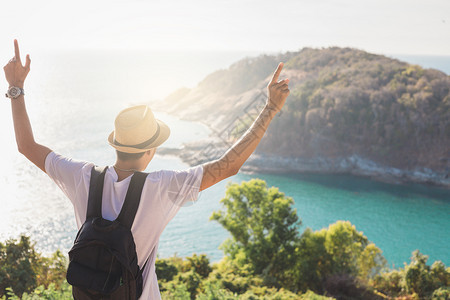 放松独自的身戴帽子人手握着他快乐的ManAsiian旅游者看着山峰和海在日落前的活动生方式在户外自由或旅行游激励背包客到19岁或图片