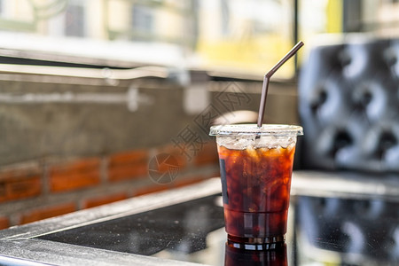 冰滴咖啡素材友好早餐卡布奇诺在咖啡馆厅的玻璃木办公桌服务台咖啡厅桌上在商业工作构想期间关闭了美式冰咖啡或黑杯中的背景