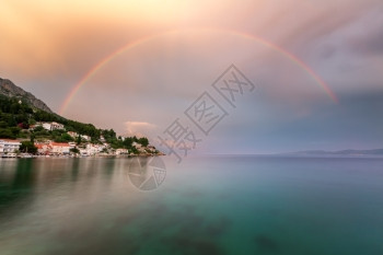 海滨在克罗地亚达尔马提Dalmatia雨后奥米斯里维埃拉小村庄上的彩虹中海亚得里图片