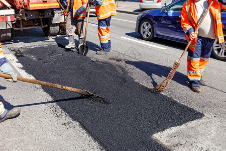 车道公路工人作组在指定路段上铺设新沥青将放入指定路段并平整道以修筑公工作组修复了运输线上选定地区维修车图片