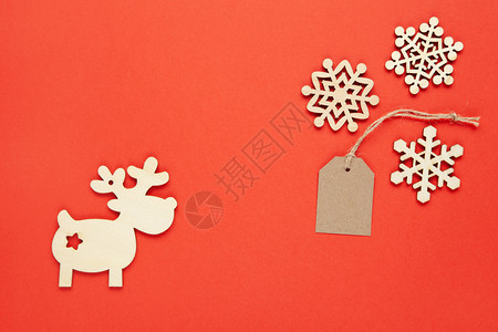 圣诞装饰三个小木雪花手工标签明红背景鹿新年节日销售生态友好概念横向平淡地最低风格简约小冬天图片