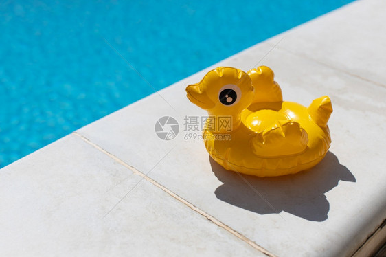 黄色的充气小鸭子阳光明媚的白天在游泳池附近的鸡尾酒摊台复制暑假概念娱乐水空气日光浴健康观塑料放松图片