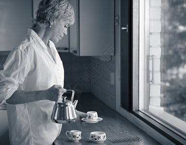 清晨成年女人在厨房喝咖啡阳光从窗外照出来自窗户的阳光早晨金发家图片