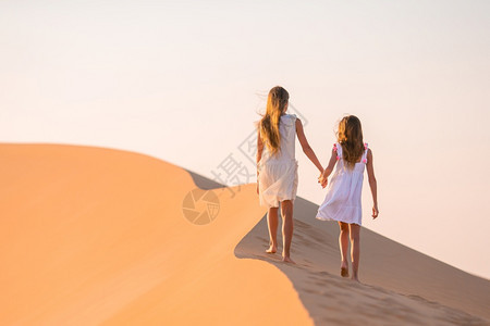 团结的在世界上最大沙漠中的丘上小美少女日落时在阿拉伯联合酋长国RubalKhali沙漠中的丘女孩扎比荒芜图片
