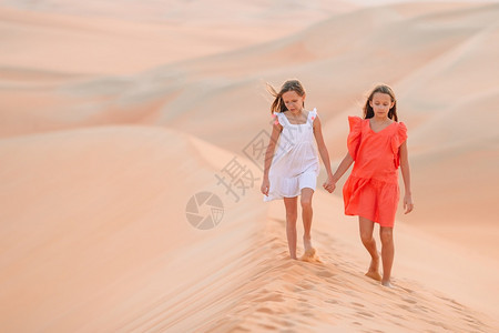 世界最大沙漠中丘上的小美少女在阿拉伯联合酋长国鲁布哈利沙漠中女孩在丘上阿拉伯联合酋长国RubalKhali沙漠中女孩在丘上团结的图片