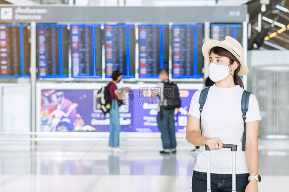 戴面罩在机场候机的女性图片