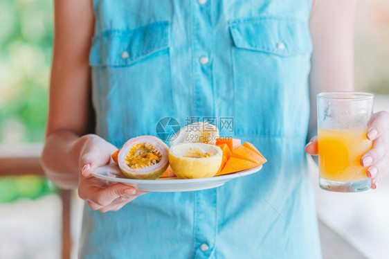 松弛美味的异国水果成熟百香女手中的户外咖啡厅早餐芒果美味的异国水果成熟的百香果户外餐厅的早芒果刷新甜点图片