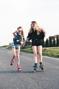 笑的年轻女孩在夏日共度愉快的滚溜短裤坦率随意的图片