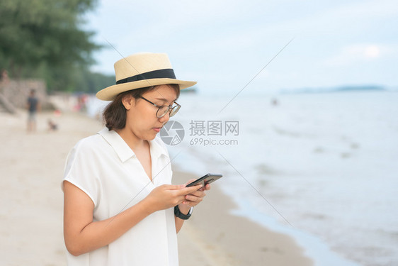 可爱的美貌年轻女子拿着智能手机为了从相电话Sefie旅游中单独拍摄自己的照片只拍自画像摄影头发自拍图片