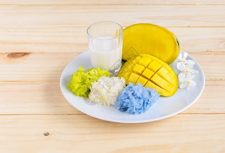 芒果和有椰子奶的天然彩粘糊米泰德芒果和含有蓝色白颜的天然黑黏糊大米其中蓝色为Pandanus叶提取品蓝色为Pandanus豆叶提图片