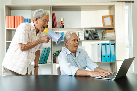 覆盖亚洲老人大呼叫用扩音器与一位交流朋友谈听不耳聋的老朵原因中沟通问题概念注意力商业图片