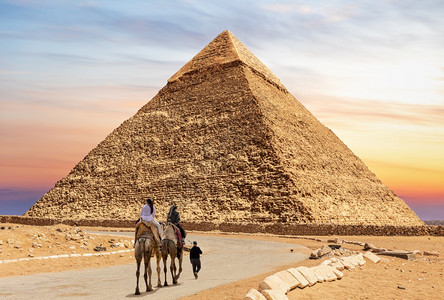 靠近蓝色的伟大埃及Chephren金字塔附近的骆驼和贝杜因旅游者图片