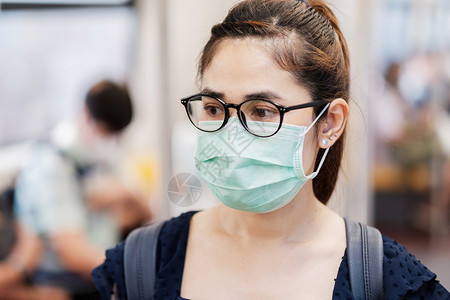 在地铁上佩戴口罩的青年女性图片