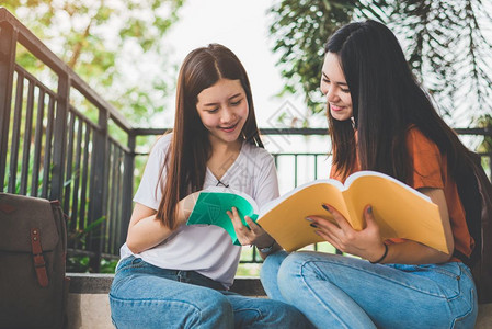 坐在楼梯上看书的两个女孩子图片