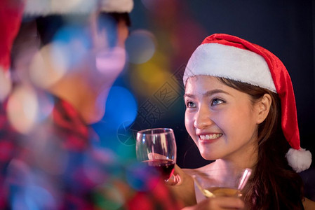 人们酒精亚裔女在圣诞节和新年派对上看男友时在圣诞和新年晚宴中看到她的男朋友夜生活与初恋概念第一印象和幸福概念夫妻和情侣主题喝图片
