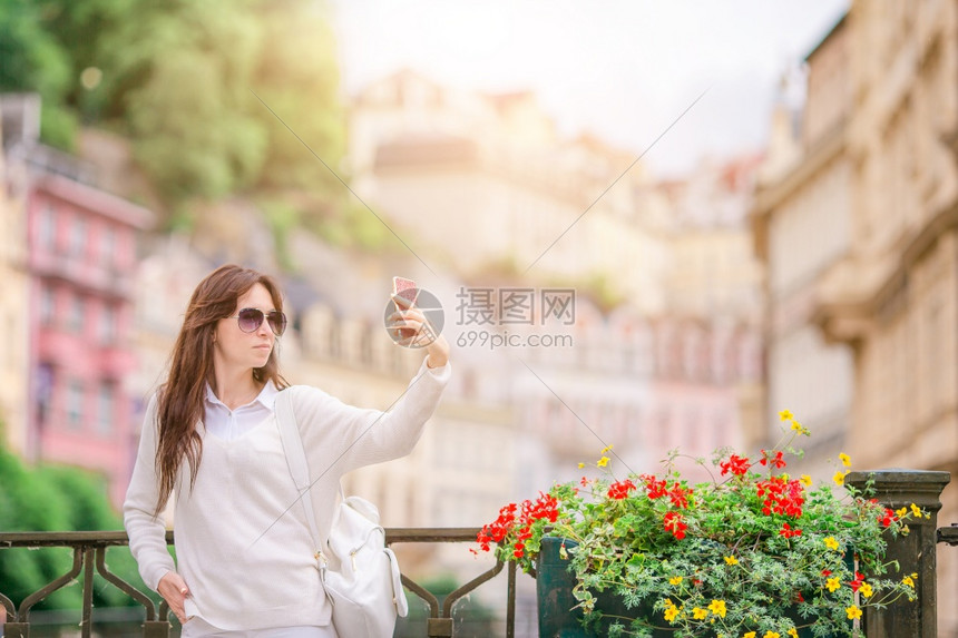 城市移动女孩在老城度假的年轻美女在捷克KarlovyVary自拍时白高加索旅游者在欧洲荒无人烟的街道上行走图片