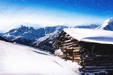 旅行书坠落高海拔木屋小雪飘落阿尔卑斯山脉为背景高海拔小木屋雪飘落在阿尔卑斯山背景图片