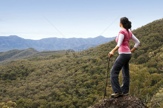 顶峰跋涉合身单女远足者在山下看望着风景图片