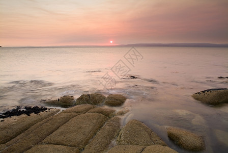 风景海岸一幕的粉色日落光目地支撑图片