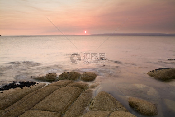 风景海岸一幕的粉色日落光目地支撑图片