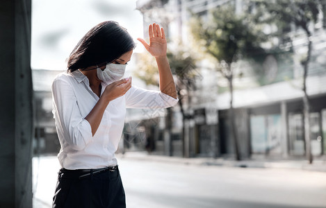 天气在职的流感Covid19或Corona或空气污染PM25情况概念年轻女在公共场合使用医疗面具进行搜捕图片