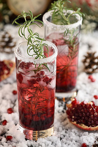 玻璃杯和石榴玛格丽塔与罐头红莓迷迭香完美鸡尾酒为圣诞派对龙舌兰酒手环完美的图片