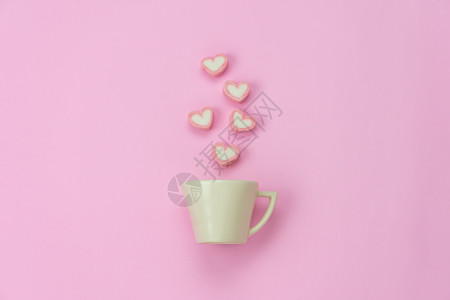 咖啡店在主办公桌工作室Pastel音调设计时用现代粉色纸上的蒸汽心形白咖啡杯安排色在现代粉红纸上装有蒸心形状问候浪漫背景图片