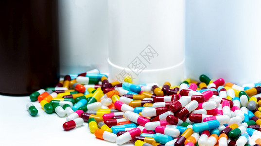 处方白色的一堆五颜六抗生素胶囊丸在模糊塑料药瓶上抗生素耐药物过度使用制药业包装图片