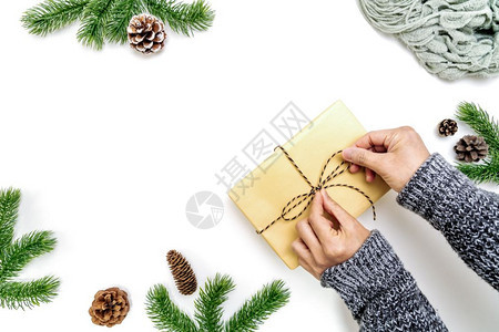 银盒子夜晚女手用松锥白色背景的圆形树枝平铺顶视图复制空间包装圣诞礼物盒的妇女手并包图片