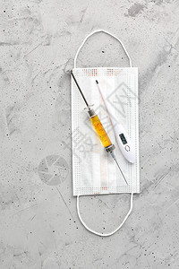 医疗面具电子温度计和注射针筒在灰色混凝土背景下使用黄色疫苗防止流感和冷冻的概念防止流感和冷藏空间纵向形象防范流感和冷冻的概念灰色图片
