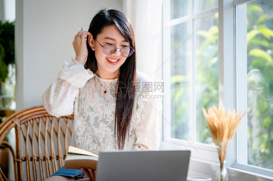 商业女人用笔记本电脑和咖啡杯及智能手机在咖啡店商业生活方式做零用笔记的散工在网吧潮人线的美丽图片
