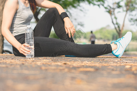 自然一名健身妇女坐在户外公园健康运动概念的街上喝着一瓶水在街上坐着道和平图片