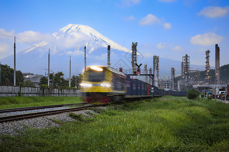 柴油机炼厂石和工业厂区和集装箱货物流火车运输开放照明动前方有Fuji山和蓝天背景的地面露天照明运动车站力量背景图片