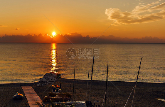 目的地旅游黎明时清晨平静的海面与一个有船的岩石海滩航行图片