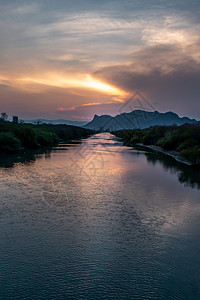 喜悦丘陵自然湖边的美丽景象太阳落山后加上水中闪耀的金色光芒向夜空反射美丽的风景照亮了夜晚的空图片