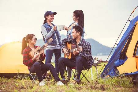 户外露营冒险的青年人弹琴唱歌图片