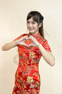 快乐的亚裔妇女以传统的中文或青相礼向亚洲妇女致意手举欢迎表达是新年庆典红金式的爱传来心象征魅力戏服图片