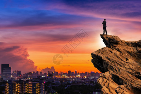 身穿舒适便衣外套的商人在山峰顶上抱起胸前拥期待着城市风景背成功竞争和领袖概念商业者向前展望一理想愿景企业家穿着舒适的散装夹克站在背景图片