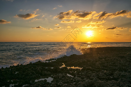 日落时在珊瑚岩石上喷出惊人的海水加勒比古巴旅行天空风景优美图片